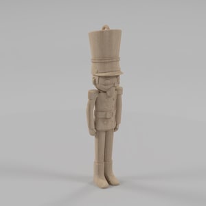 Könnte beinhalten: Eine Holzfigur eines Spielzeugsoldaten, der aufrecht steht. Die Figur ist hellbraun und hat einen hohen Hut, eine Jacke mit Schulterklappen und Stiefel. Eine klassische Weihnachtsdekoration.