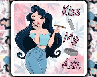 May include: A cartoon illustration of a woman with long black hair, wearing a blue crop top and jeans, blowing a kiss. The text "Kiss My Ash" is written in pink and white letters. There is a lit cigarette, a lighter, and an ashtray in the image.