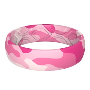May include: Pink camouflage silicone ring. The ring features a pattern of light and dark pink shapes. The inside of the ring has a textured design. This ring is a fashion accessory.