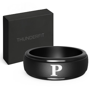 May include: A black ThunderFit ring with a white letter "P" is displayed next to a black box with the brand name. The ring has a wide band design. The box is rectangular and has the brand name "THUNDERFIT" embossed on it.