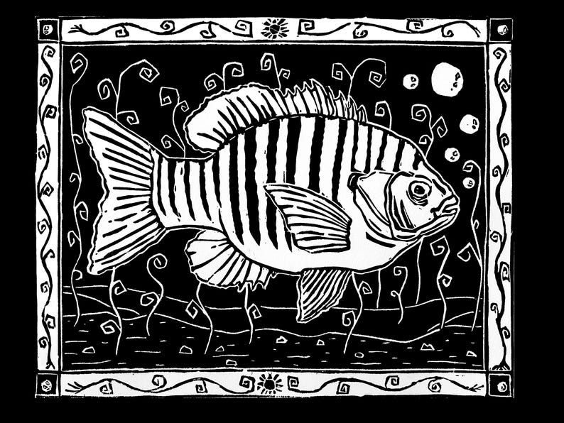 May include: Black and white linocut print of a fish with striped markings, surrounded by stylized aquatic plants and bubbles. The artwork is framed with a decorative border featuring swirling patterns and sun-like motifs.