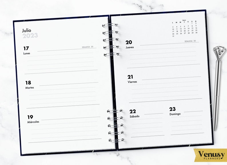 May include: A two-page spread from a July 2023 planner with a black and white starry design. The left page shows the dates 17, 18, and 19 with the days of the week listed as Lunes, Martes, and Mi&eacute;rcoles. The right page shows the dates 20, 21, 22, and 23 with the days of the week listed as Jueves, Viernes, S&aacute;bado, and Domingo. The right page also includes a small calendar for the month of August.