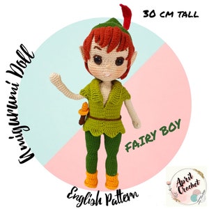 May include: A handmade amigurumi doll of a fairy boy, approximately 12 inches tall. The doll is wearing a green outfit with a matching hat and orange boots. The doll has red hair and is holding a small accessory. The text "Fairy Boy" and "English Pattern" are visible.
