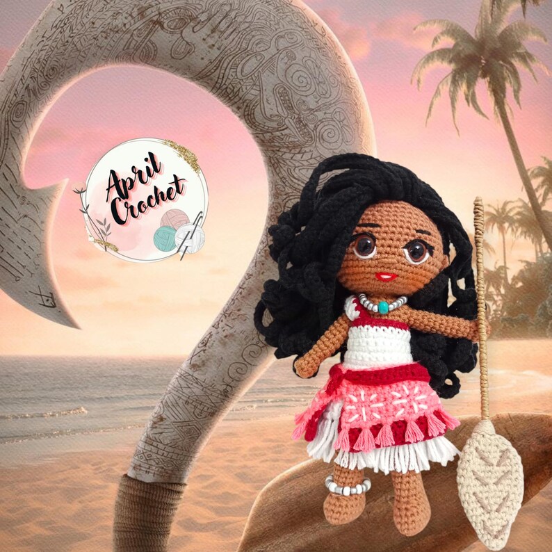 Może przedstawiać: Lalka Moana z filmu Disneya Moana, wykonana na szydełku, ubrana w czerwoną i białą sukienkę z kwiatowym naszyjnikiem. Lalka trzyma drewniane wiosło z wzorem liścia. Tło to scena zachodu słońca z palmą i drewnianym hakiem.