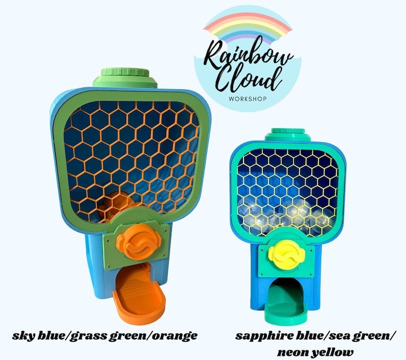 Op de afbeelding: Twee kleurrijke kauwgomballenautomaten. E&eacute;n is hemelsblauw, grasgroen en oranje. De andere is saffierblauw, zeegroen en neongeel. Beide hebben een honingraatpatroon aan de voorkant. De tekst "Rainbow Cloud Workshop" staat op de achtergrond.