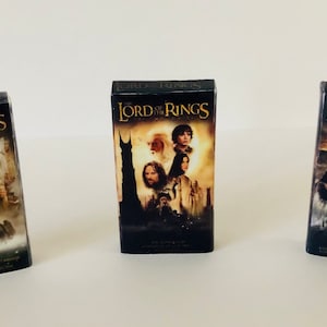 Peut inclure: Trois cassettes VHS de la trilogie Le Seigneur des anneaux. La Communauté de l'anneau, Les Deux Tours et Le Retour du roi.