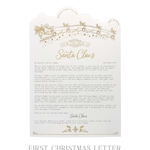 May include: A white letter from Santa Claus with gold foil accents. The top features a sleigh and reindeer illustration with the text Official North Pole Mail. The body contains a printed message addressed to a child for their first Christmas.