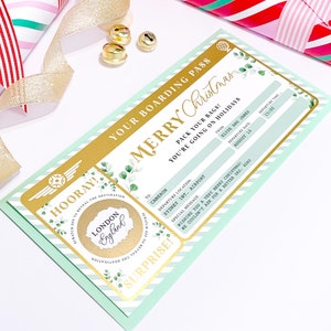 May include: A boarding pass-themed Christmas card with the text "Merry Christmas" in gold. The card features a mint green and gold color scheme, with a "Scratch off to reveal the destination" element. The destination is London, England.
