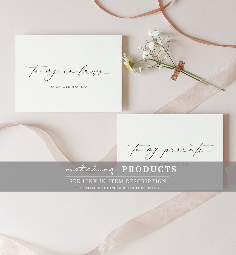 May include: Two white cards with black calligraphy. The top card says "To my in-laws" and the bottom card says "To my parents". Both cards have the text "On my wedding day" underneath the main text. The cards are on a light pink background with a white flower and a pink ribbon.