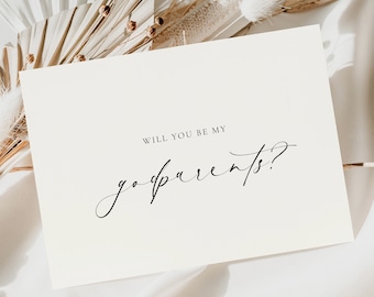 May include: A rectangular off-white card featuring the black printed text WILL YOU BE MY godparents? in a combination of clean sans-serif and elegant cursive script fonts, presented on a smooth, light-colored fabric surface.