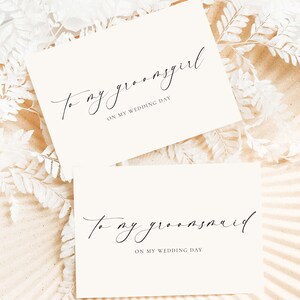 May include: Two white cards with black calligraphy. The top card says "To my groomsgirl on my wedding day". The bottom card says "To my groomsmaid on my wedding day".