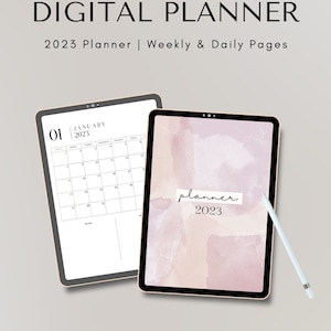 May include: Two digital tablets, one with a calendar for January 2023 and the other with a pink watercolor background and the text "planner 2023".