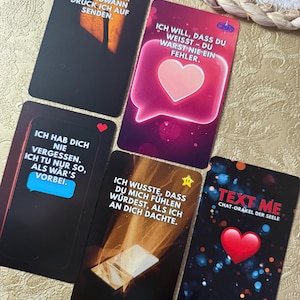 May include: A collection of oracle cards with various designs and text. The cards feature phrases like "Text Me" and "I will, that you know - you were never a mistake." The cards have a dark background with colorful accents.