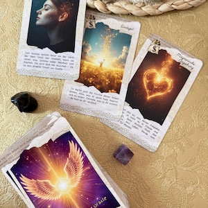 May include: A collection of oracle cards with various illustrations and text. The cards feature images of a woman, a person in a field, and a glowing heart. The text includes phrases like "Sacred Guidance Oracle" and German text.