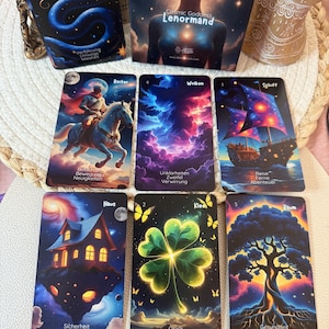 May include: A Cosmic Goddess Lenormand tarot card deck with several cards displayed. The cards feature colorful illustrations of a rider on a horse, a house, a ship, a four-leaf clover, and a tree. The deck box shows a woman with a cosmic background.