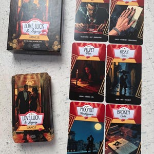 May include: A deck of "Love, Luck & Legacy Oracle" cards with a matching box. The cards feature illustrations with text such as "Big Bluff," "Diamonds & Secrets," and "Moonlit Rendezvous." The box and cards have a vintage aesthetic.