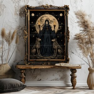 May include: A framed wall art print featuring a central figure in a black hooded cloak holding two lit torches, flanked by two wolves. The background displays a large full moon, stars, and a dark night sky, all enclosed in an ornate black frame.