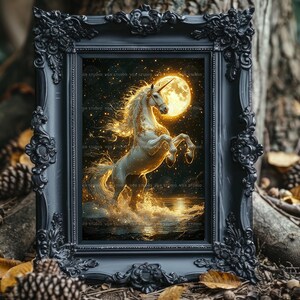 May include: A framed print featuring a white unicorn rearing up in front of a full moon. The artwork has a fantasy theme, with golden light and stars in the background. The frame is black with ornate detailing.
