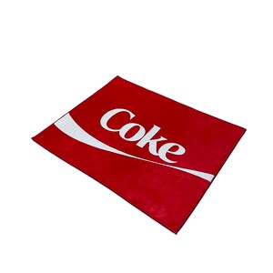 May include: Red doormat with a white Coca-Cola logo.
