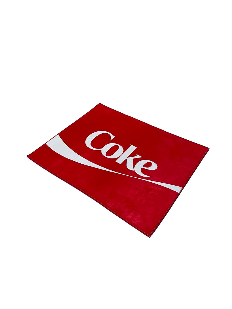 May include: Red doormat with a white Coca-Cola logo.