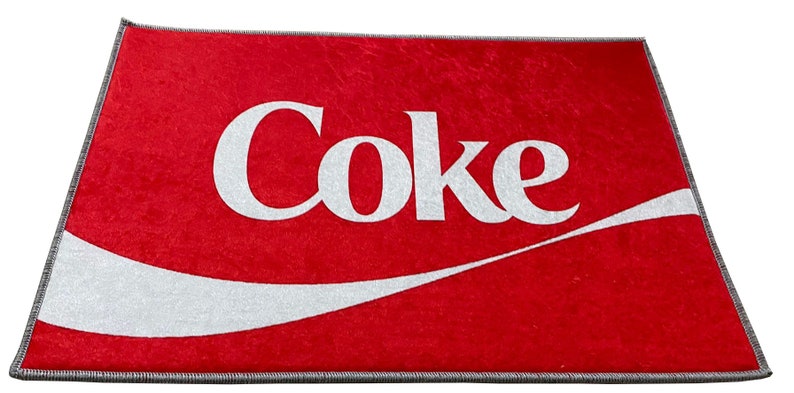 May include: Red doormat with a white Coca-Cola logo and a white wave design.