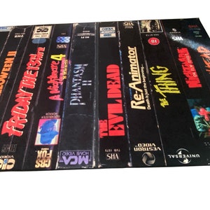 May include: A collection of VHS tapes featuring horror movie titles, including Halloween, Friday the 13th, Phantasm, The Evil Dead, Re-Animator, The Thing, and Pumpkinhead.