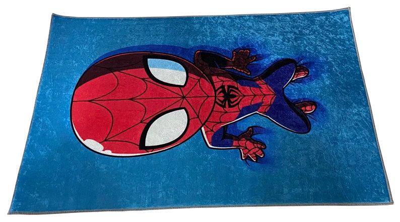 May include: A blue rug with a cartoon image of Spiderman in a red and blue suit. Spiderman is upside down with his head and one leg in the air.