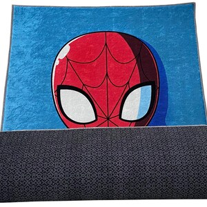 May include: A blue and red rug with a cartoon image of Spider-Man's face. The rug has a gray backing.