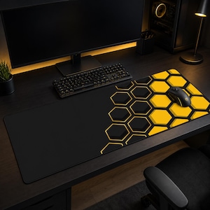 Könnte beinhalten: Schwarzes und gelbes Gaming-Mauspad mit Wabenmuster. Das Pad hat eine große Oberfläche, eine schwarze Tastatur und eine schwarze Maus. Das Design ist eine Kombination aus schwarzen und gelben Sechsecken.