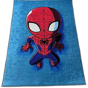 May include: A blue fleece blanket with a cartoon image of Spiderman in a red and blue suit. The Spiderman character is in a crouching position with his arms outstretched.