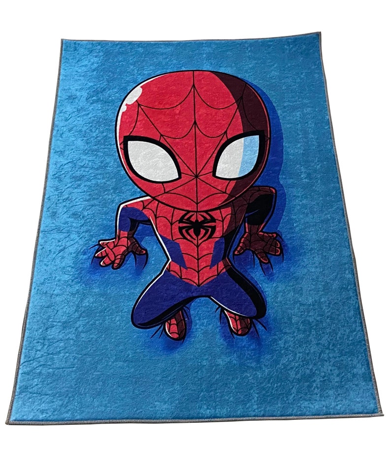 May include: A blue fleece blanket with a cartoon image of Spiderman in a red and blue suit. The Spiderman character is in a crouching position with his arms outstretched.
