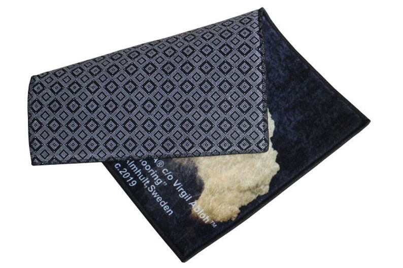Pu&ograve; includere: Un tappeto con motivo bianco e nero con un design astratto beige e marrone. Il tappeto ha il testo "c/o Virgil Abloh" e "Imhult, Svezia" stampato su di esso.