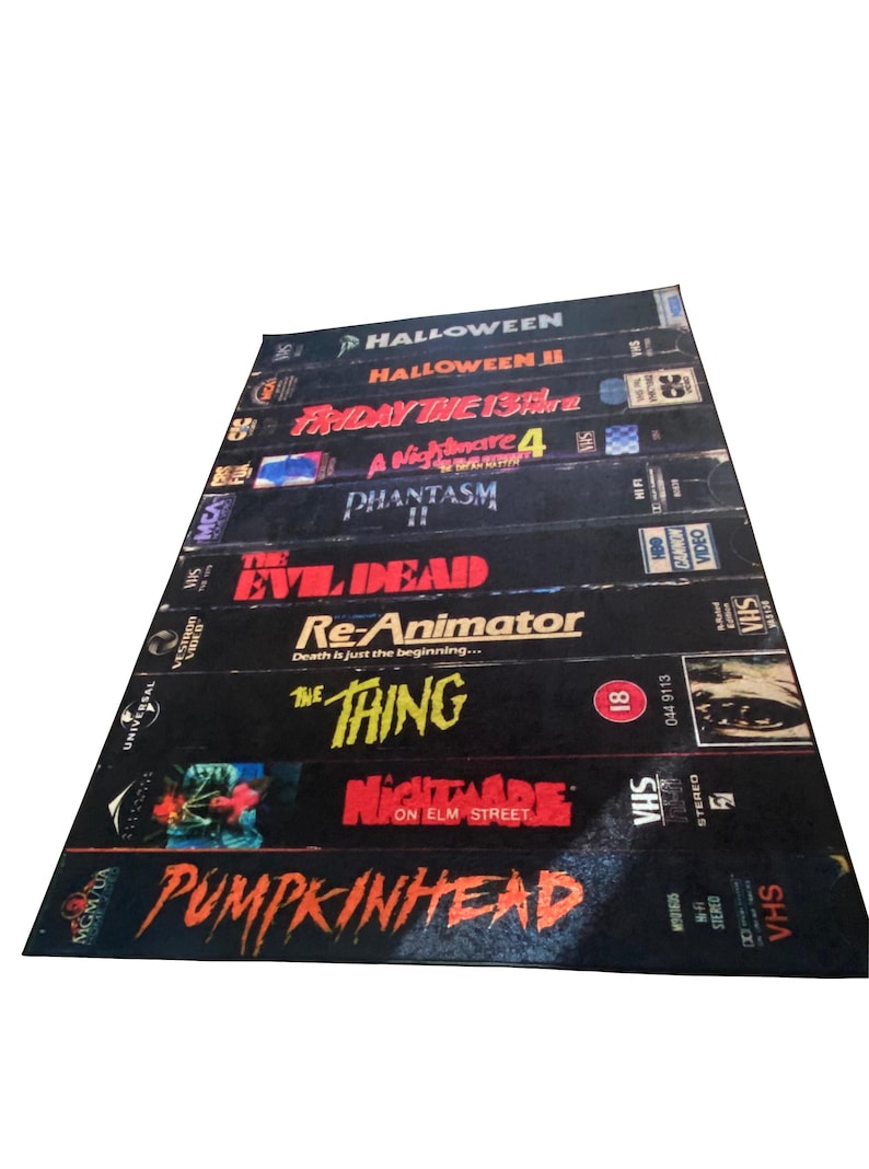 May include: A stack of VHS tapes featuring horror movie titles including Halloween, Friday the 13th, A Nightmare on Elm Street, and The Thing.