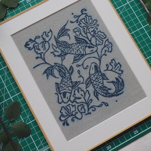 Linocut art print in indigo ink on natural irish linen featuring swimming koi fish and William Morris inspired botanical designs. Framed in a frame package. 8x10 inches.