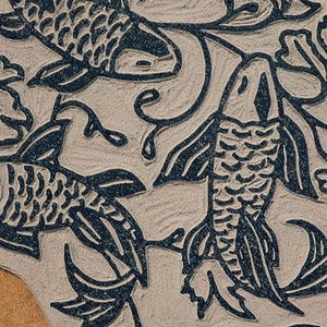 Linocut block for art print in indigo ink on natural irish linen featuring swimming koi fish and William Morris inspired botanical designs. Framed in a frame package. 8x10 inches.