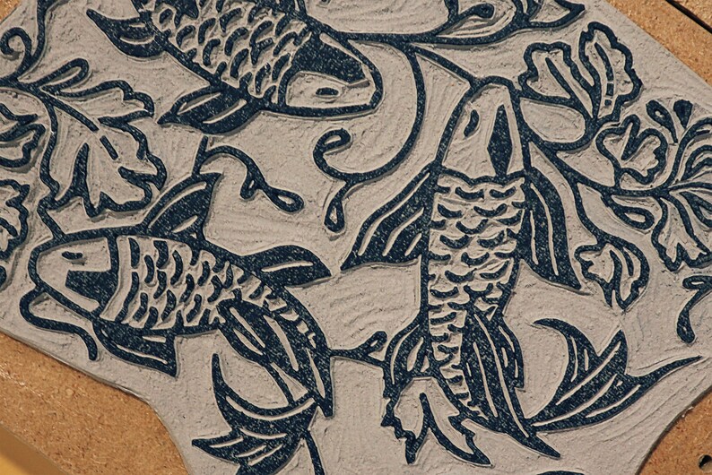 Linocut block for art print in indigo ink on natural irish linen featuring swimming koi fish and William Morris inspired botanical designs. Framed in a frame package. 8x10 inches.