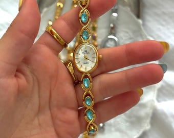 Reloj ovalado de oro vintage, pulsera de piedras preciosas azules, joyería femenina delicada.