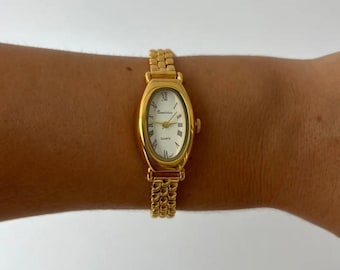 Reloj ovalado dorado para mujer: reloj de vestir minimalista con brazalete y números romanos.