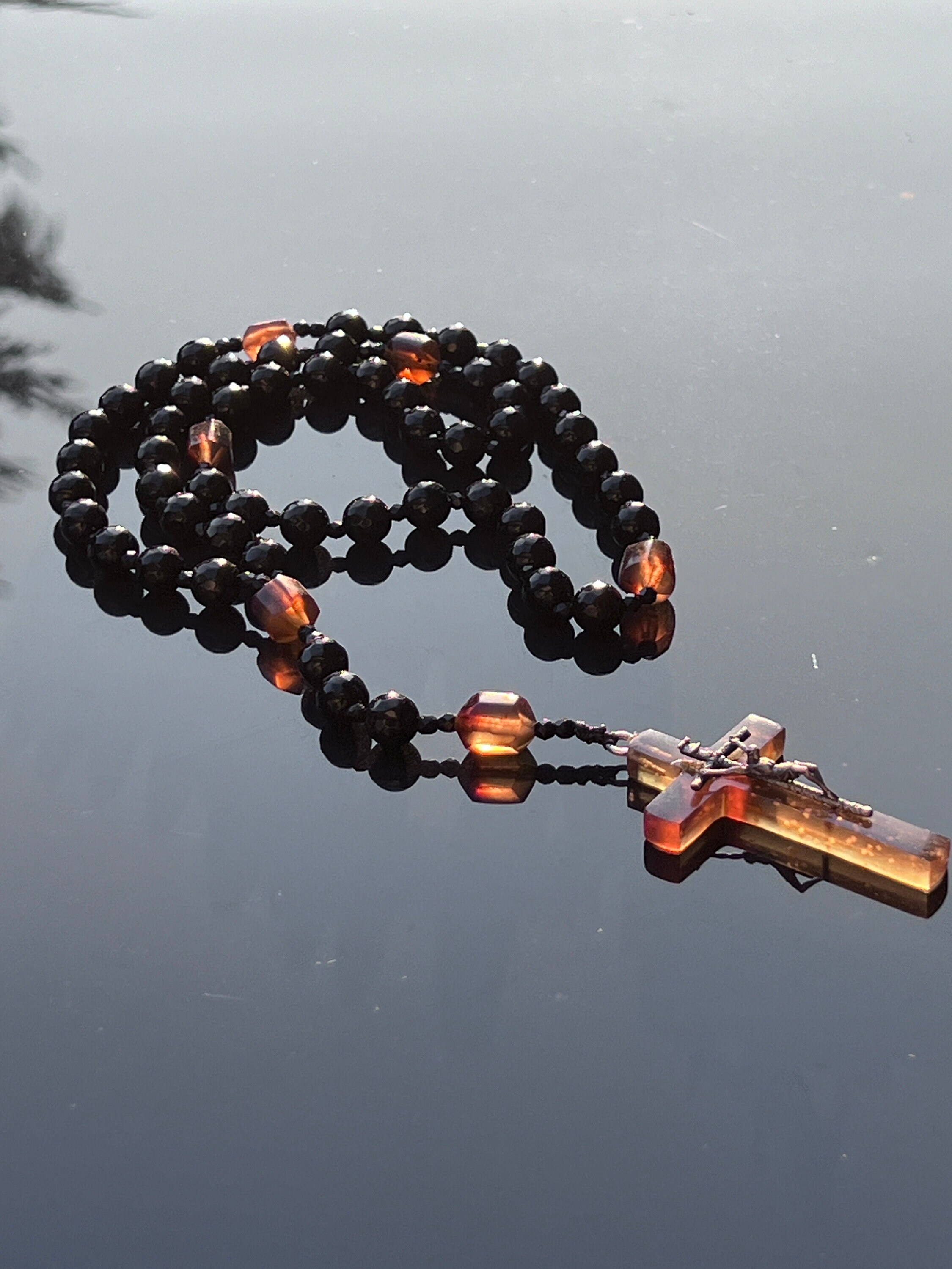 Catholic Rosary of Black Onyx and Amber with John Paul II Silver Cross This rosary is anointed with the oil of Saint Charbel from Lebanon