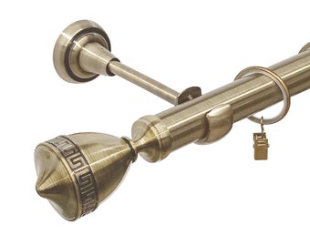 May include: A gold metal curtain rod with a decorative finial and rings. The rod is mounted to a wall with a bracket.