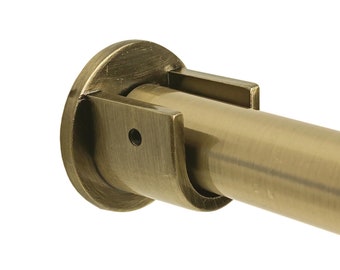 May include: A close-up of a gold-toned metal curtain rod bracket. The bracket has a round base and a curved arm that holds the rod.