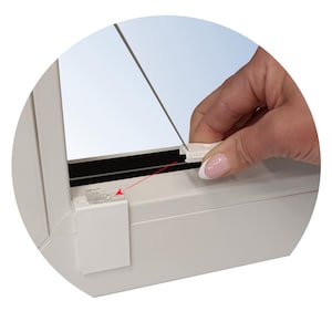 Puede incluir: Primer plano de un marco de ventana blanco con un cristal transparente. Se muestra una mano instalando un pequeño clip de plástico blanco. El clip se inserta en un marco blanco a juego. El fondo es un cielo azul claro.