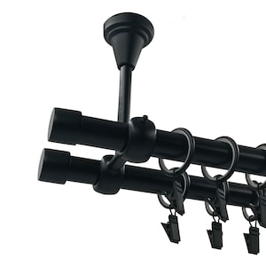 Può includere: Bastone per tende doppio nero con montaggio a soffitto e terminali decorativi. Il bastone ha anelli e clip per appendere le tende.