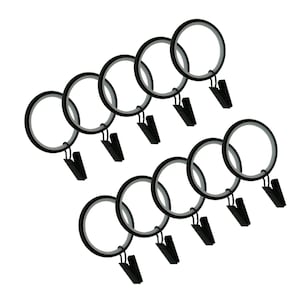 Könnte beinhalten: Ein Satz von zehn schwarzen Gardinenringen mit Clips. Jeder Ring ist kreisförmig mit einem schwarzen Außenrand und einem silbernen Innenrand. Die schwarzen Clips sind an der Unterseite jedes Rings befestigt.