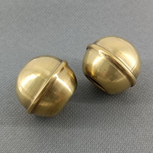 Handmade vintage pair of gold brass sheet ball-shaped curtain rod finials