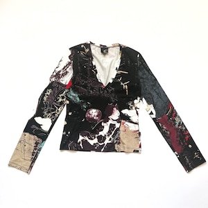May include: Black long-sleeved shirt with a colorful abstract print featuring a woman and floral designs. The shirt has a V-neck.