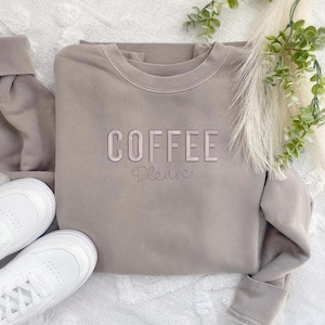 May include: A light brown sweatshirt with the text "COFFEE Please" in pink lettering.