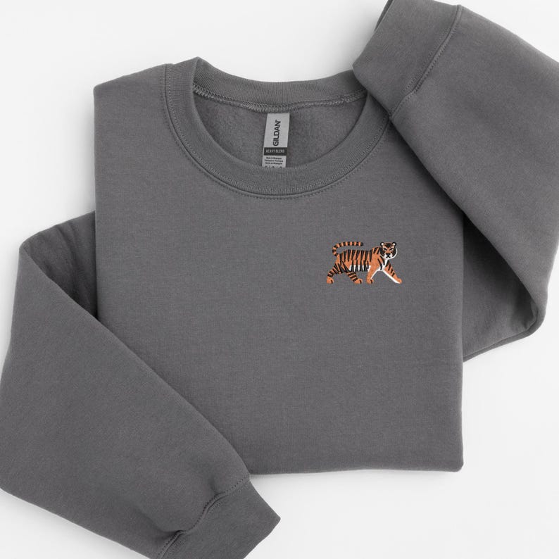 May include: A charcoal gray sweatshirt with a small embroidered tiger on the left chest.