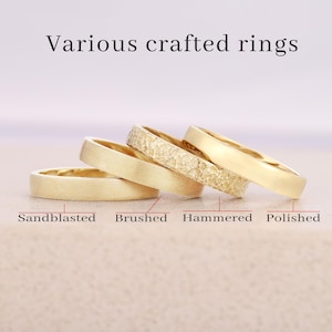 May include: Four gold rings arranged in a row, each featuring a distinct surface texture. The text "Various crafted rings" appears at the top, with labels "Sandblasted," "Brushed," "Hammered," and "Polished" pointing to each specific ring.