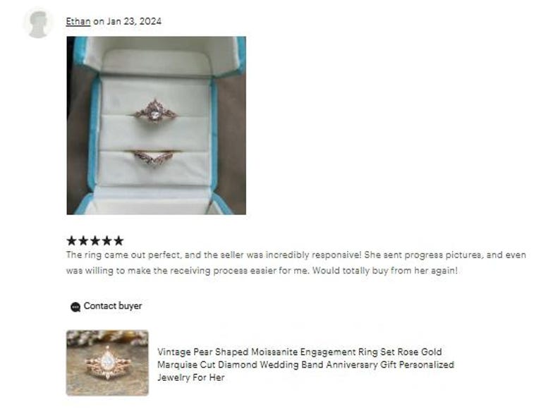 May include: A rose gold engagement ring set in a light blue ring box. The set includes a pear-shaped moissanite engagement ring and a marquise cut diamond wedding band. The ring is a vintage style.